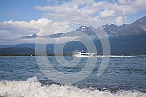 Tour boat cruises in Resurrection Bay near Seward Alaska on a sunny afternoon