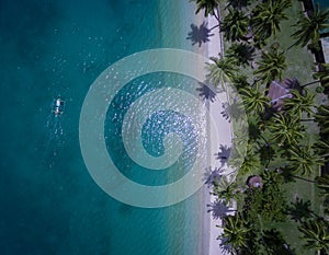 A tour boat drives to an island in Port Barton Palawan Philippines photo