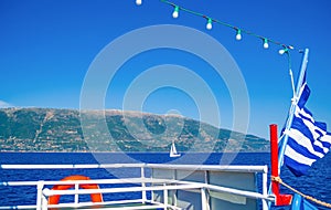 Tour boat navigating in blue Ionian Sea Ithaca island Greece