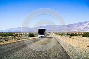 Tour bus driving through Death Valley National Park, California