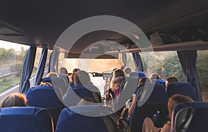 tour on the bus. People travel by bus. Salon of the great tourist bus with people at sunset