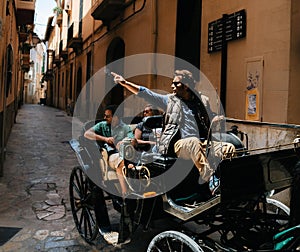 Tour guide in horse carriage points a hand at a landmark, Mallorca, Spain