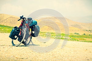 Touring bicycle stand on scenic gravel road in nature. Fully loaded touring machine with copy space background