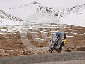 Touring motorcycle and snow covered mountains