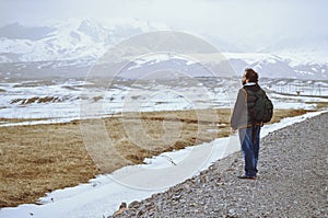 Touris wearing backpack and standing at the rural road photo