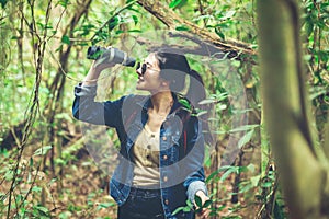 Tourism asian lifestyle women and traveler with backpack adventure holding map to find directions in the jungle forest destination