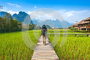 Tourism with backpack walking on wooden path, Vang vieng in Laos