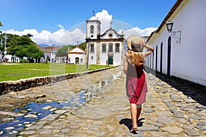 Tourism in Brazil. Back view of beautiful girl with walking towards the Church of Saint Rita of Cassia in Paraty, Brazil