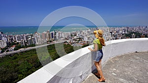 Tourism in Brazil. Panoramic view of traveler woman with hat in Vila Velha city, Vitoria metropolitan region, Espirito Santo,