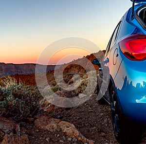 Tourism car on off road with sunset landscape. Close up view of blue car