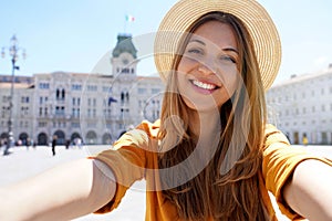 Tourism in Europe. Self portrait of smiling young tourist woman visiting Trieste, Italy