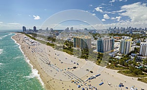 Tourism infrastructure in southern USA. South Beach sandy surface with tourists relaxing on hot Florida sun. Miami Beach