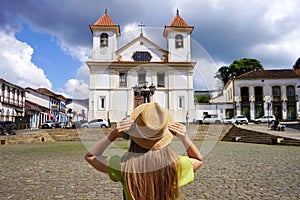Tourism in Mariana, Brazil. Back view of young tourist woman in Mariana Cathedral square in Minas Gerais, Brazil