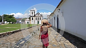 Tourism in Paraty, Brazil. Girl walking in the historic town of Paraty, UNESCO World Heritage Site, Rio de Janeiro, Brazil. Slow m