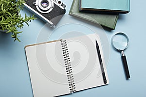 Tourism, travel concept. Office desk table with notepad, camera and supplies. Top view. Copy space for text.