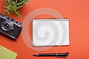 Tourism, travel concept. Office desk table with notepad, camera and supplies. Top view. Copy space for text.