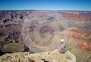 Tourist admiring multicoloured rocks with dozens of layers in Grand Canyon