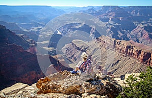 Tourist admiring multicoloured rocks with dozens of layers in Grand Canyon