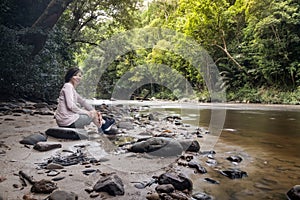 Tourist admiring scenic nature view of Tahan River bank with lush rainforest foliage at Taman Negara National Park