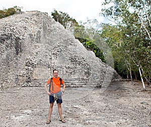 The tourist against pyramid ruins Mexico. Archeologic zone Kabah.