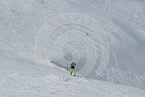 Tourist in alps photographs the valley below him. Swiss Alps and only one freeride man. Young boy downhill slope and stop before a