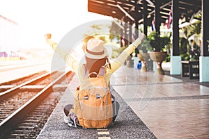 Tourist asian lifestyle women wearing backpack holding map, traveler siting for waiting a train, so happy and relax