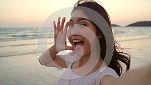 Tourist Asian woman selfie on beach, young beautiful female happy smiling using mobile phone taking selfie on beach near sea when