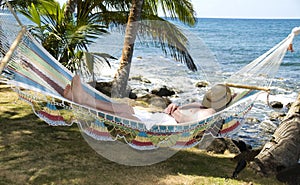 Tourist asleep in hammock by the caribbean sea