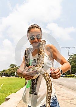 Tourist attraction, people/tourists petting a snake in Colombo, Sri Lanka, 2020