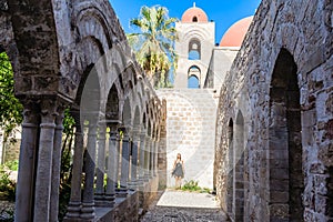 Tourist on background of cloister of the arab-norman church 