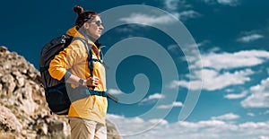 Tourist with a backpack against the sky, panorama. Portrait of a traveler in yellow clothes against the sky. Portrait of a woman