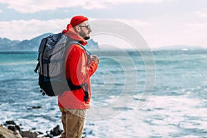 Tourist with a backpack on the background of the sea, rear view. A man in tourist gear on the background of the sea.