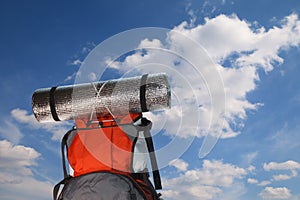 Tourist backpack on blue sky background