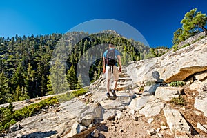 Tourist with backpack hiking in mountains