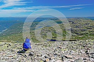 Tourist with backpack hiking to Gaustatoppen