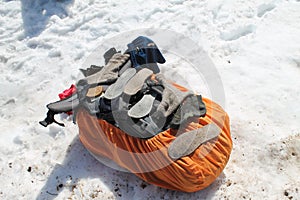 A tourist backpack lies in the snow. Socks and insoles are dried