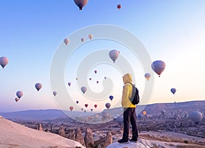 A tourist with a backpack see on soaring hot air balloons in Cappadocia, Turkey, concept achievement, team, leader