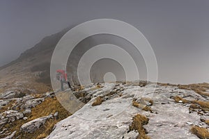 Tourist with backpack sitting on the edge of a precipice