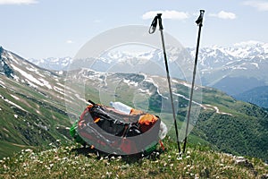 Tourist backpack and ski poles are lying on top