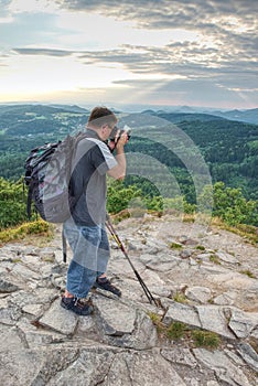 Tourist with backpack walk on mountain rocks