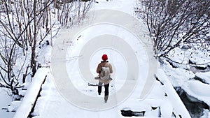 A tourist with a backpack is walking in a winter snow forest. Active recreation and hiking