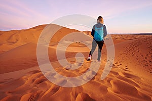 Tourist backpacker girl on a hike in Sahara desert