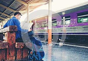 Tourist backpacker using map to travel at train station