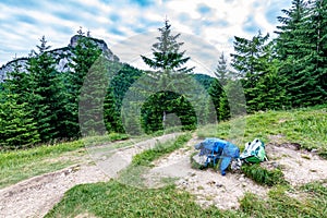 Tourist bagpack and krosna placed on the meadow near Maly Rozsutec mountain in Mala Fatra national park. Green and blue bags used