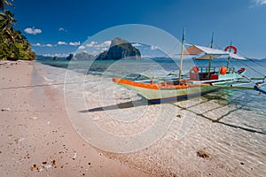 Tourist banca boat on beach ready for island hopping with beautiful scenery of surreal Pinagbuyutan island in background