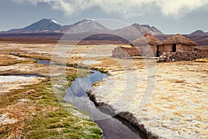 Tourist bathing in hot springs, Sajama national park, with volcano Parinacota and Pomerape in the background, Bolivia