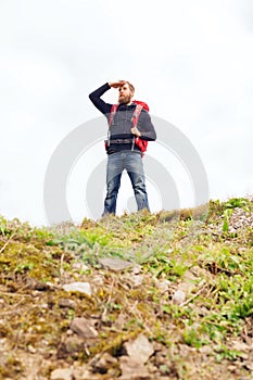 Tourist with beard and backpack looking far away