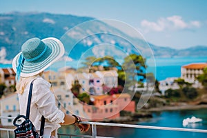 Tourist blond women with sun hat in cute colorful small Assos village. Kefalonia, Greece