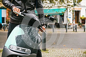 The tourist boarded an electric scooter. A popular vehicle in the city is called an electric scooter. In the background