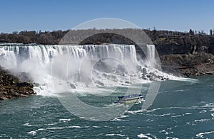 A Tourist Boat Carrying People Passing Niagara Falls USA and Heading Towards Niagara Falls Canada